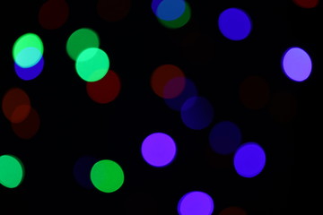 Christmas background black with blue, green and red circles. Bokeh. Out of focus christmas garland