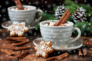 Tasses avec des biscuits au chocolat chaud et au pain d& 39 épice sur une table en bois