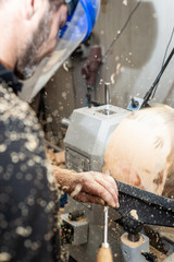 man wood work with mortise chisel a rotating pice of timber