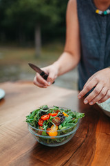 Detail of Woman preparing salad for dinner outside