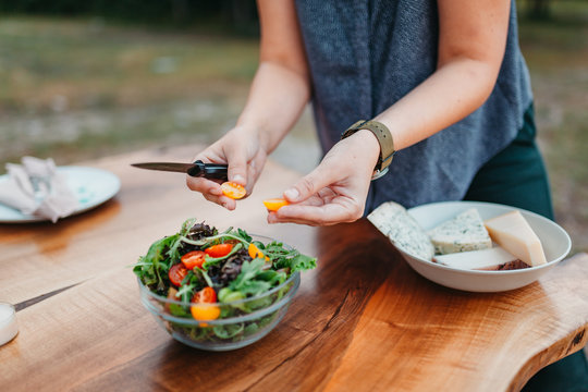 Detail Of Woman Preparing Salad For Dinner Outside