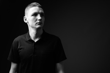 Young man against black background in black and white