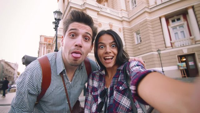 POV of the young mixed race tourist couple taking selfie in old city center and having some fun