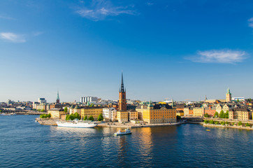 Fototapeta na wymiar Aerial panoramic top view of Riddarholmen district with Riddarholm Church and typical sweden gothic buildings, boat ship sailing on water of Lake Malaren from Sodermalm island in Stockholm, Sweden