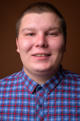 Obraz premium Studio shot of overweight young man against brown background