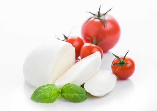 Fresh Mozzarella cheese with tomatoes and basil leaf on white background.