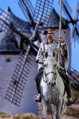 Don Quixote on horseback, with the windmills behind