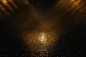 glitter vintage lights background. black and gold. de-focused.