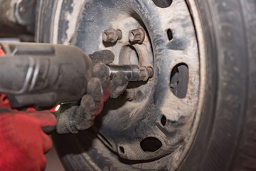Car mechanic changes tires in the repair shop