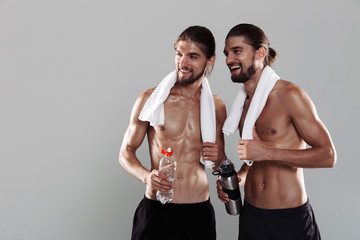 Portrait of a two smiling muscular shirtless twin brothers