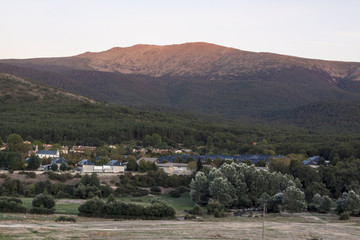 Village of Valsain, known for its wood. Donkey grazing, typical houses and peak of Peñalara. In Sierra de Guadarrama National Park, Segovia, Spain