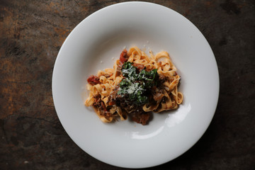 Pasta Fettuccine Bolognese with beef and tomato sauce on wood background in dark tone mystic light style
