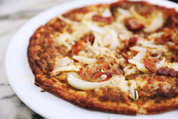 Pizza with crispy bacon onion on outdoor table