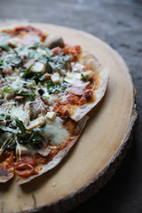 Pizza with  ham tomatoes mozzarella cheese and basil. Delicious italian pizza on wooden pizza board