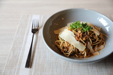 spaghetti Bolognese with minced beef and tomato sauce garnished with parmesan cheese and basil , Italian food