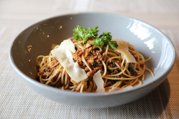 spaghetti Bolognese with minced beef and tomato sauce garnished with parmesan cheese and basil , Italian food