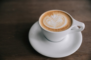 cappuccino or Latte art coffee made from milk on the wood table in coffee shop