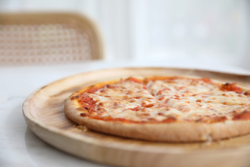 pizza margarita on wood dish in coffee shop background