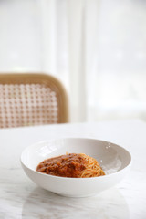 spaghetti Bolognese with minced beef and tomato sauce garnished with parmesan cheese and basil , Italian food