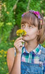 Pensive romantic teenage girl with a bouquet of dandelions