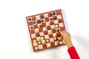 Kid hands over a chessboard playing chess game. Top view