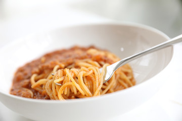 spaghetti Bolognese with minced beef and tomato sauce garnished with parmesan cheese and basil , Italian food