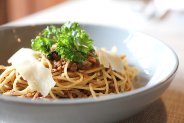 spaghetti Bolognese with minced beef and tomato sauce garnished with parmesan cheese and basil , Italian food