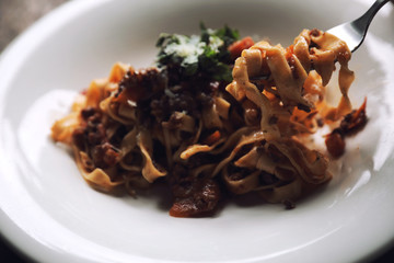 Pasta Fettuccine Bolognese with beef and tomato sauce on wood background in dark tone mystic light style