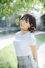 portrait of asian girl with white shirt and skirt looking in outdoor nature vintage film style