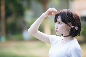 portrait of asian girl with white shirt and skirt looking in outdoor nature vintage film style