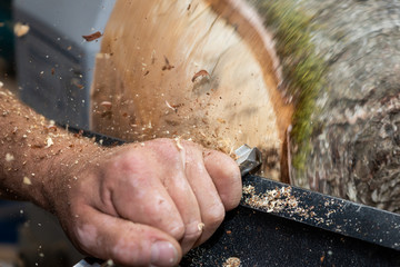wood sawdust shavings squirting while creating timber bowl on turnery