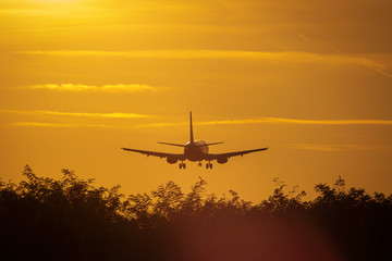Fototapeta na wymiar Silhouette of air plane landing at sunset