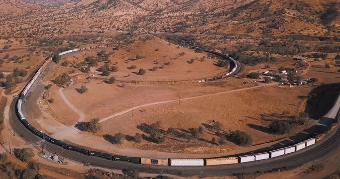 Aerial view of long freight train passing through Tehachapi Loop, California