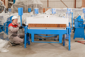 manufacture workshop. Worker unpacks the machine in the warehouse. the production of ventilation and gutters. Tool and bending equipment for sheet metal.
