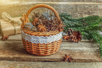 Naklejka premium Christmas New Year composition with gift box fir branch basket pine cones on old shabby rustic wooden background. Xmas holiday december decoration to Russian tradition. Flat lay, copy space