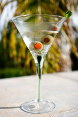 Martini cocktail with olives by the pool on vacation