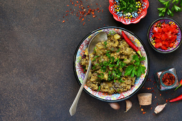 Sauteed eggplant. Salad of baked eggplants on a dark background.