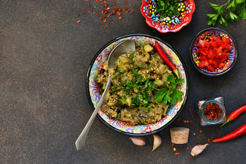 Sauteed eggplant. Salad of baked eggplants on a dark background.