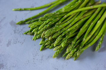 Fresh raw green asparagus bunch and english alphabet cubes at vintage background