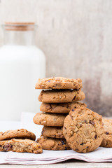 Chocolate oatmeal chip cookies with milk on the rustic wooden table.