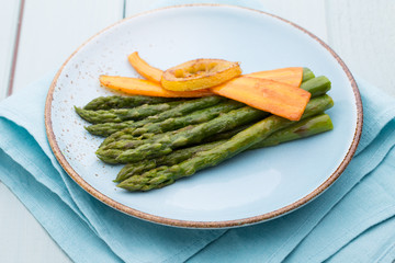 Fried asparagus with broccoli and lemon and carrot.