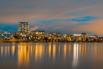 Fototapeta na wymiar Modern apartments in a medium density suburb along the river. Reflections in the water. Dusk sky. Long exposure