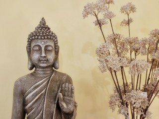 Buddhafigur mit getrockneten Pflanzen und mittigem Textfreiraum