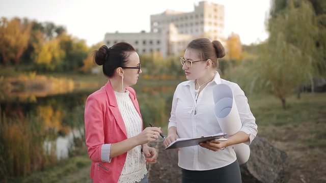 Two women agree on the documentation for the procurement of construction materials for completion of the construction of the building.