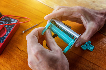 Man hands fixing modern vaporizer e-cig gadget to vape e-liquid. Maintenance of electronic...