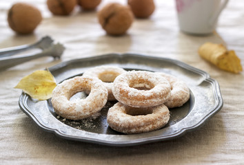 Sand dough biscuits, coffee and walnuts on a linen tablecloth. Rustic style.
