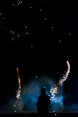 silhouette of the person on the background of smoke and firework at night