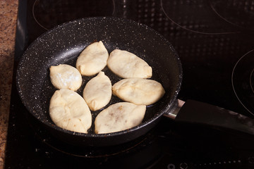 Meat pies, pan-fried in boiling oil. small raw pies in a frying pan with hot oil. copy space for text.