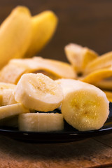 Fresh ripe banana, sliced, wooden background.