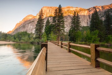 A wooden bridge with golden mountains in background - Yosemite